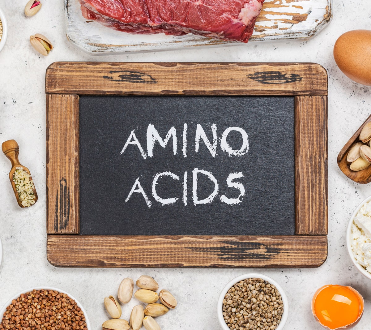Amino Acids written on a chalkboard with healthy foods surrounding